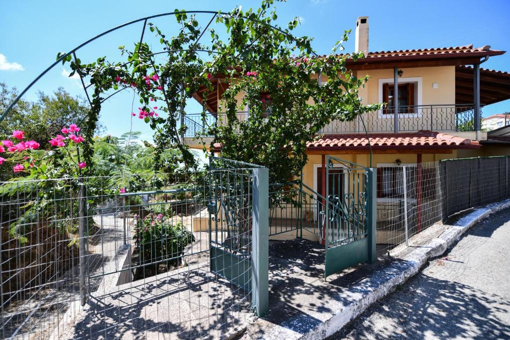 a fence in front of a house with pink flowers at Villa Koliri in Pýrgos