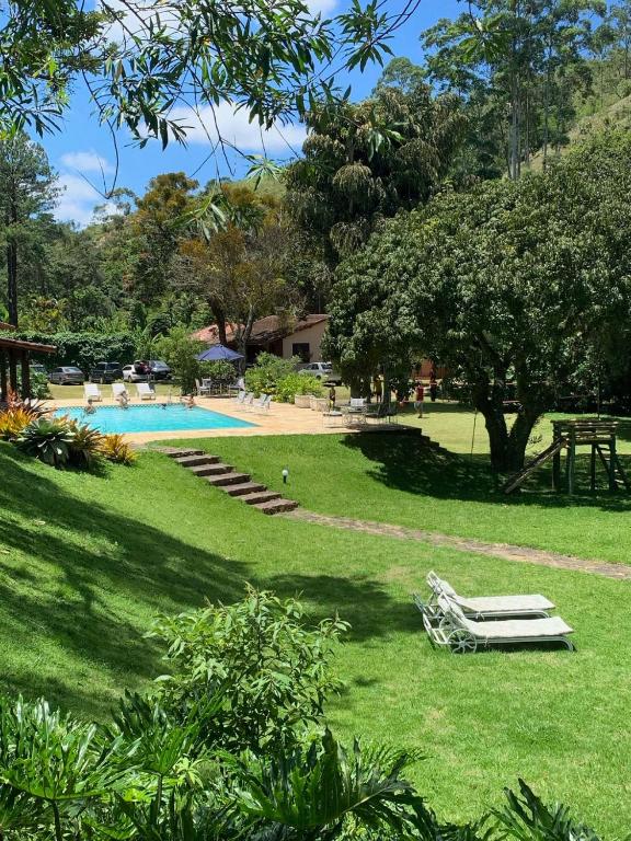 a yard with a swimming pool and trees and grass at Recanto da Paz Tur - Relax e charme na serra in Miguel Pereira