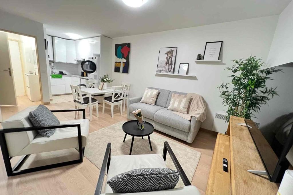 a living room with a couch and a table at Very quiet apartment with balcony in Saint-Denis