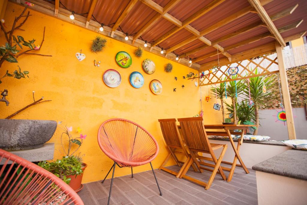 ポンタ・デルガダにあるEm Canto De Santa Claraの黄色の壁の客室で、テーブルと椅子が備わります。