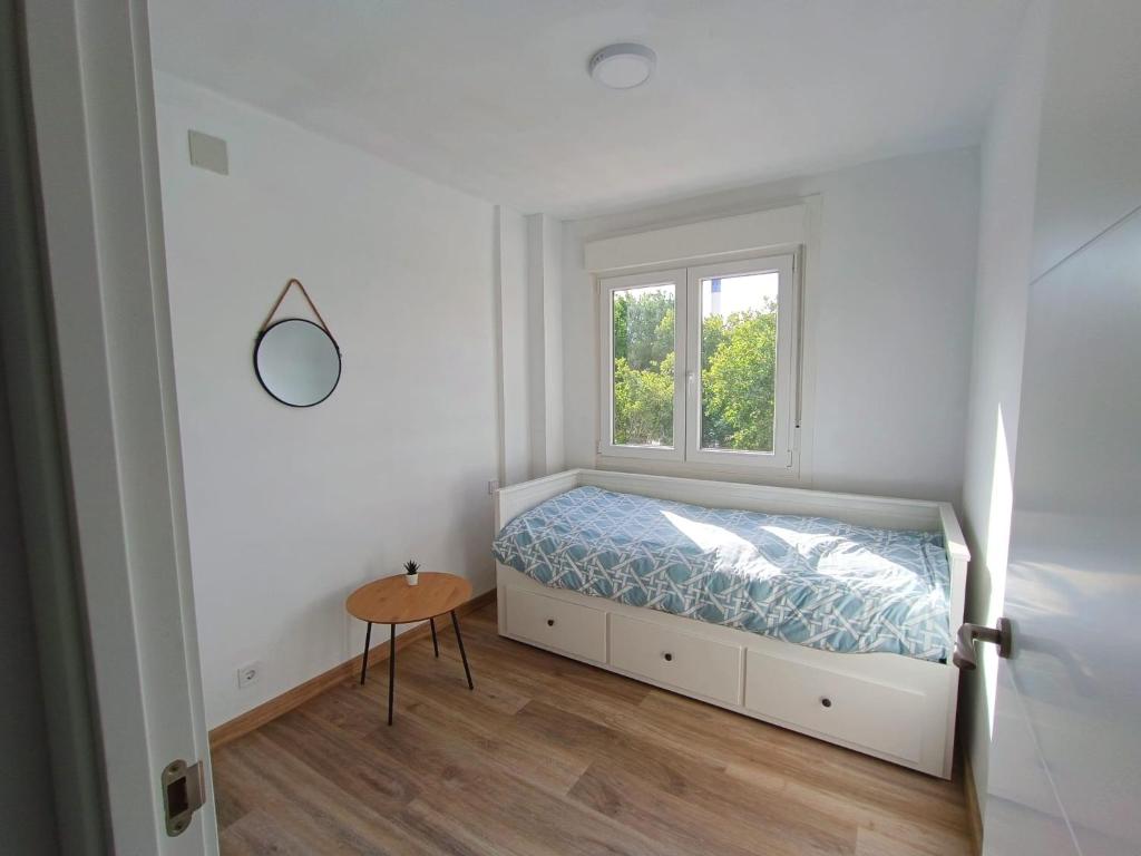 um pequeno quarto com uma cama e uma janela em La Casita de Requejo em Zamora