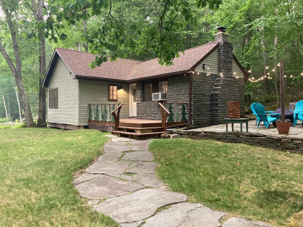 a log cabin with a deck and a patio at Cute private Wooded Cabin near the big lake in Tafton