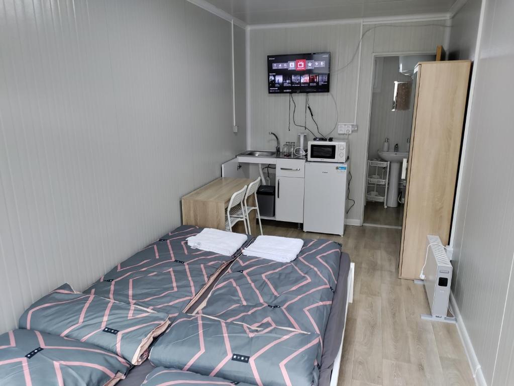 a small room with a bed and a kitchen at Domino in Hluboká nad Vltavou