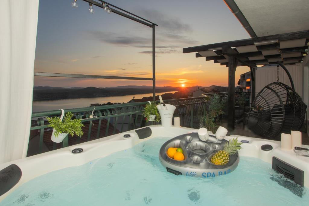 a hot tub on a balcony with a sunset at Apartment Mozart in Šibenik