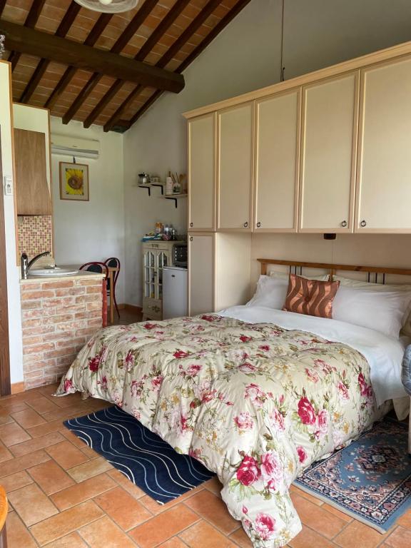 シエナにあるAgriturismo La Collinaのベッドルーム1室(花柄のベッドカバー付きの大型ベッド1台付)