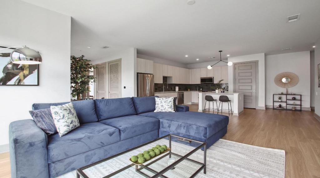 sala de estar con sofá azul y cocina en Luxury West Midtown 2 bdrm, en Atlanta