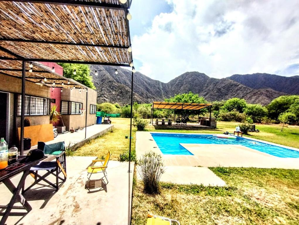 a villa with a pool and mountains in the background at Finca Los Sauces in Chilecito