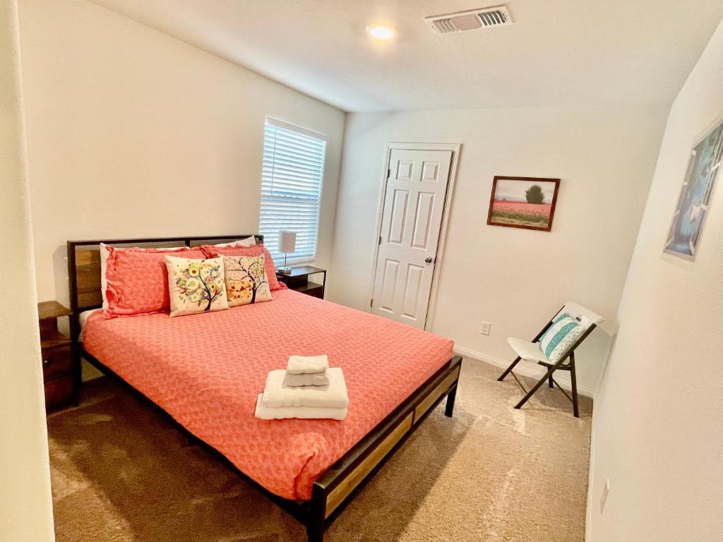 a bedroom with a bed with orange sheets and a chair at NEW House, 2023 built, 5 bedrooms, Sleeps 12, Near Las Vegas Strip and Airport in Las Vegas