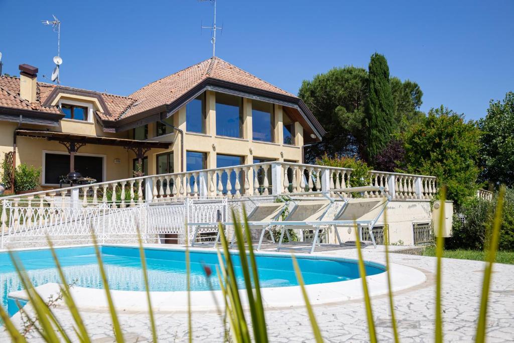 ein Haus mit einem Pool vor einem Haus in der Unterkunft Villa Rolls - Porzione di Villa con piscina,giardino e parcheggi in Riccione