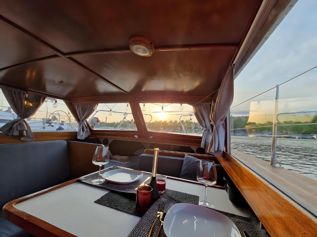 una zona de comedor en un barco con una mesa y copas de vino en Venerent, en Helsinki
