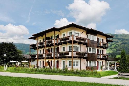 a large building with balconies on the side of a road at Sonnblick Apartments und Zimmer - Nationalpark Sommercard inklusive in Hollersbach im Pinzgau