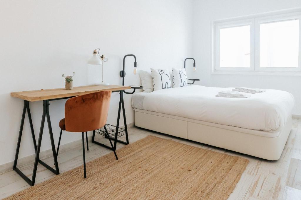 a white bedroom with a bed and a desk at Lisboa - Almirante Reis Central Apartment in Lisbon