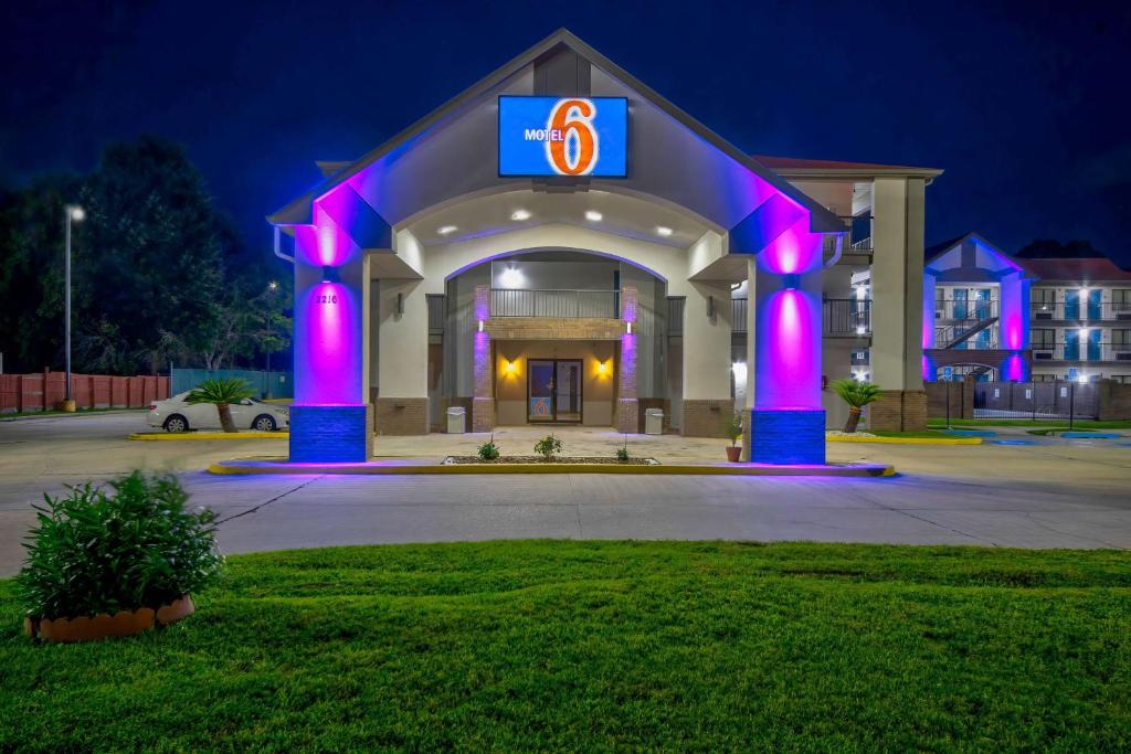 un edificio con luces púrpuras en un aparcamiento en Motel 6-Lafayette, LA, en Lafayette