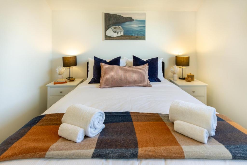 una camera da letto con un grande letto con due comodini di 2 bed Escape, Heart of Riccarton w/carpark a Christchurch