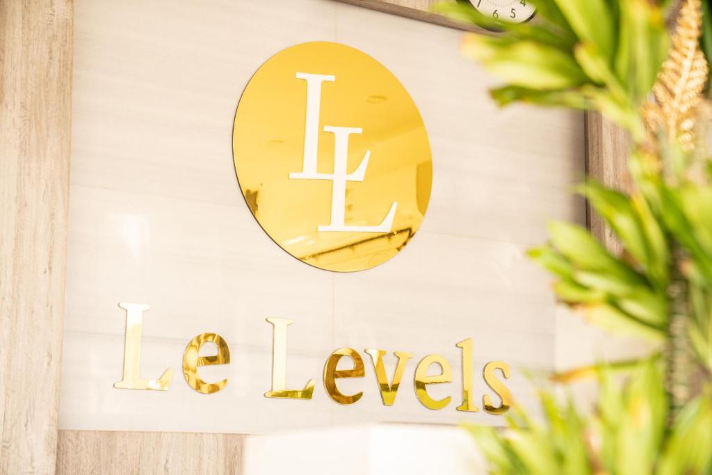 a gold sign on a wall with a mirror at Le Levels Residency in Dammam