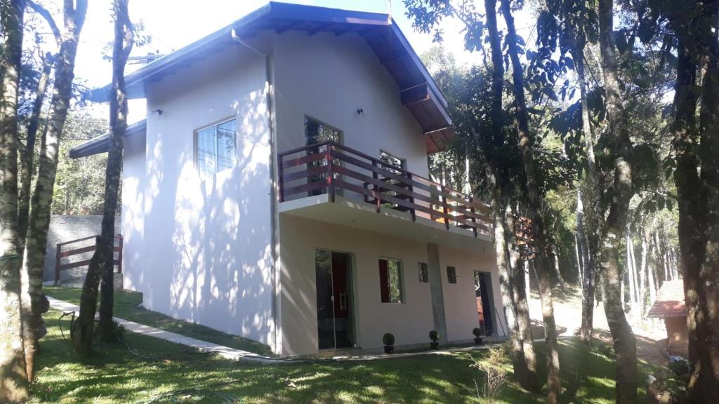 une maison dans les bois avec des arbres dans l'établissement Parada Di Maria Guest House, à Campos do Jordão