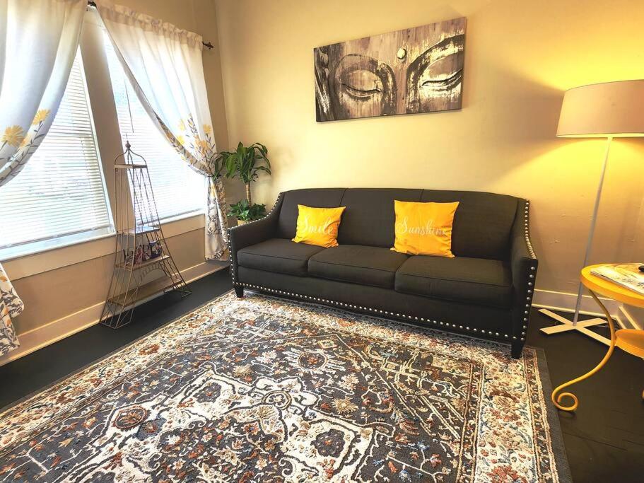 a living room with a black couch and a rug at Adorable French corner by Downtown-Houston, Heights & WOMH in Houston