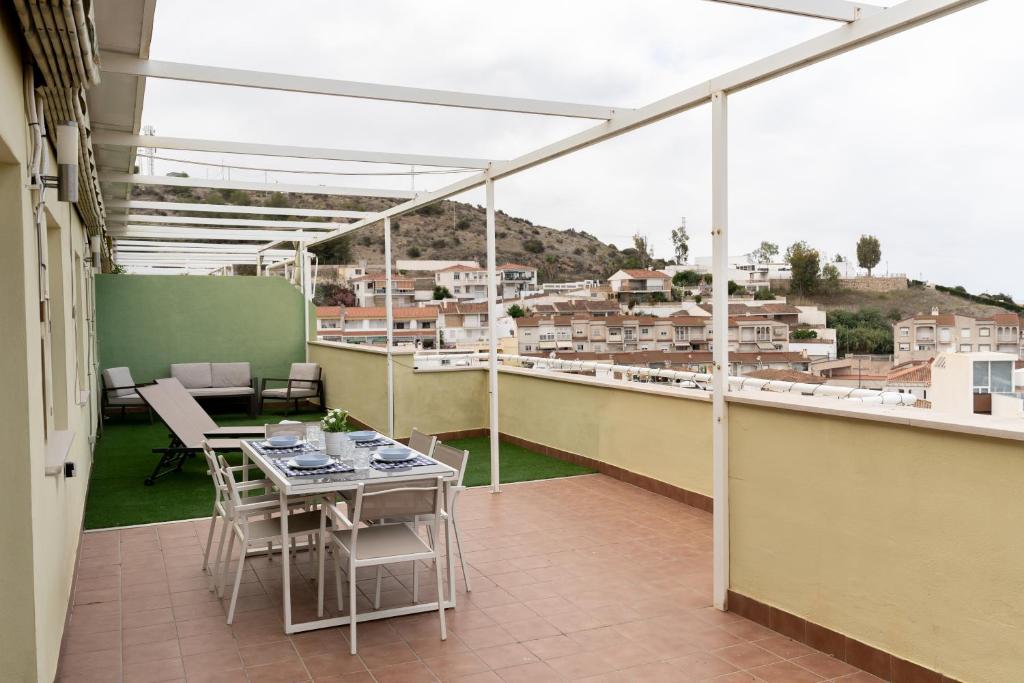 a balcony with tables and chairs and a view of a city at Mirador del Sol en Torrenueva in Torrenueva