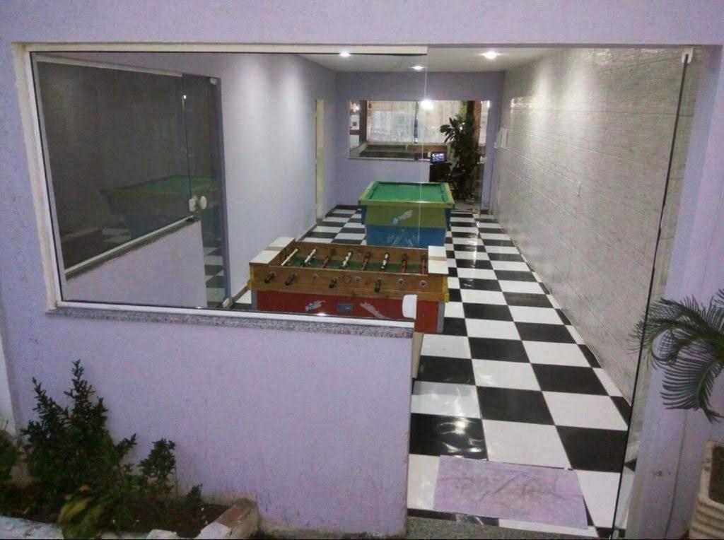 a room with a checkered floor with tables on it at Pousada Porto di Mare in São Pedro da Aldeia