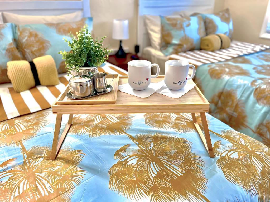a coffee table with two mugs on top of a bed at Private Guest House in Miami