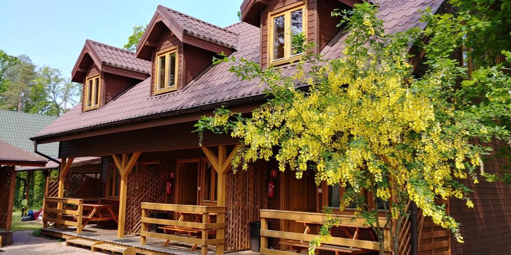 a wooden house with a gambrel roof at Letnisko Laba in Pobierowo