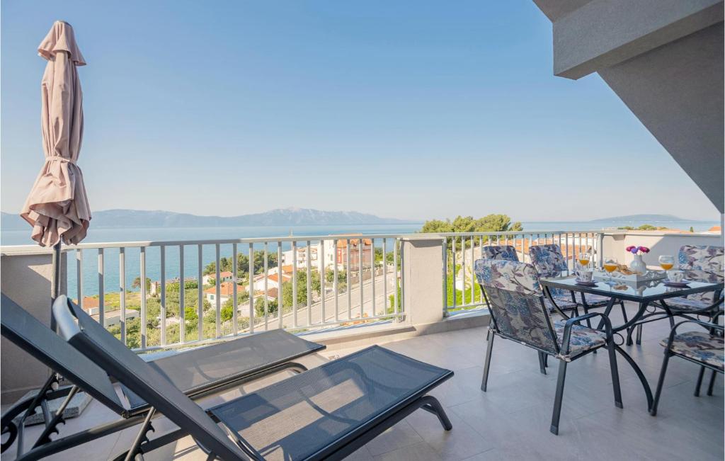 a balcony with tables and chairs and a view of the ocean at Awesome Apartment In Podaca With Kitchen in Podaca