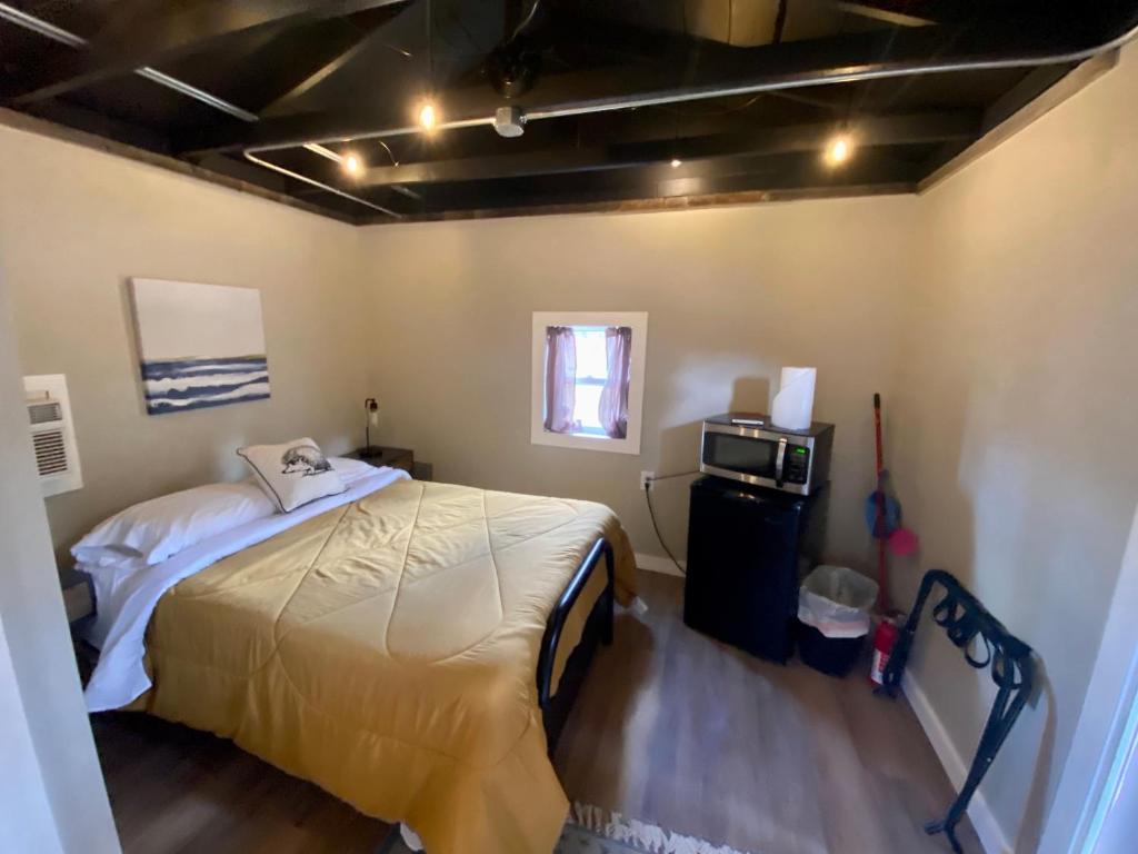 - une chambre avec un lit et un four micro-ondes dans l'établissement Cabin 7 at Horse Creek Resort, à Rapid City