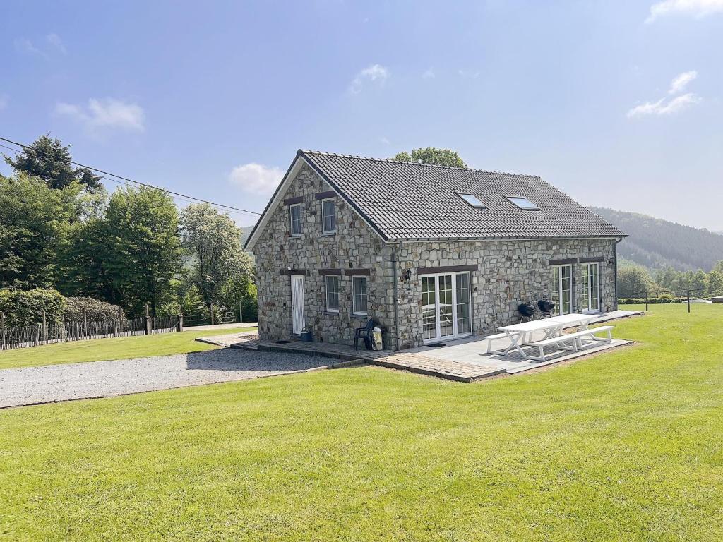 a stone house on a field with a grass yard at Bra de Pierre in Lierneux