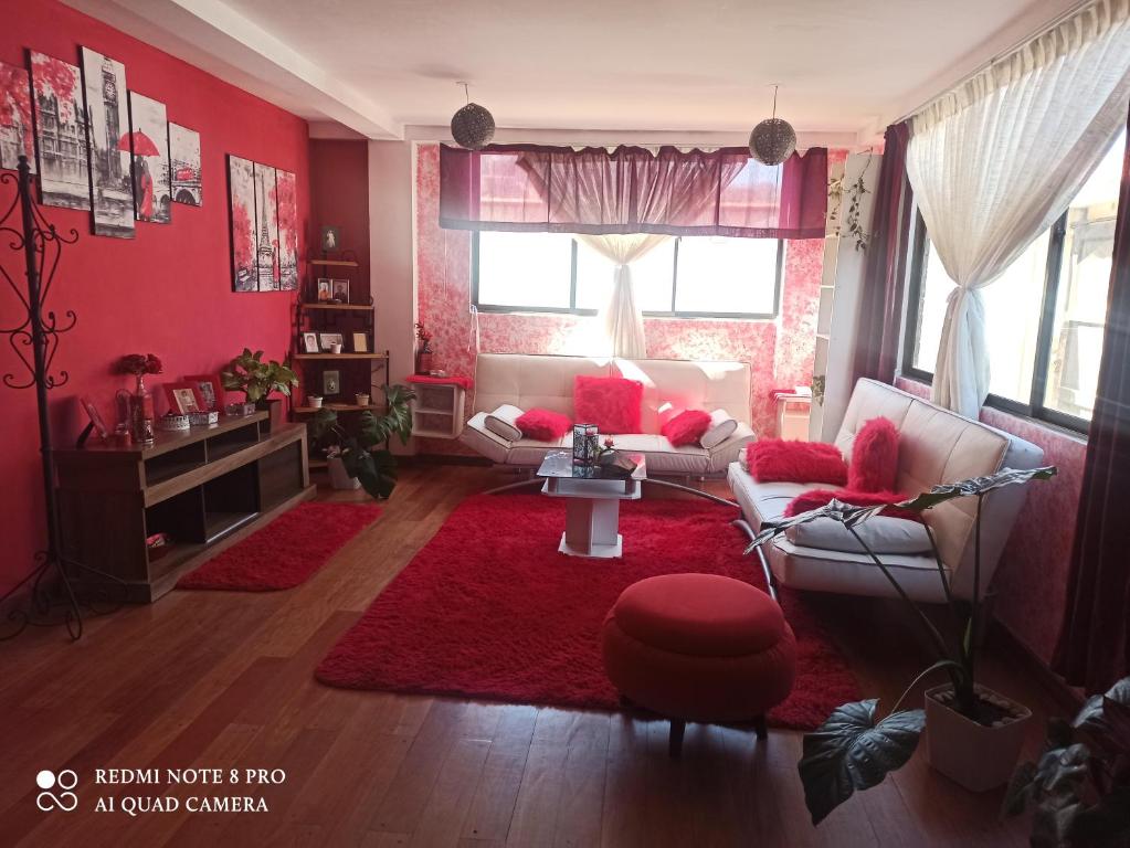 a living room with red walls and a red rug at DEPARTAMENTO JOSE MARIA in Achumani