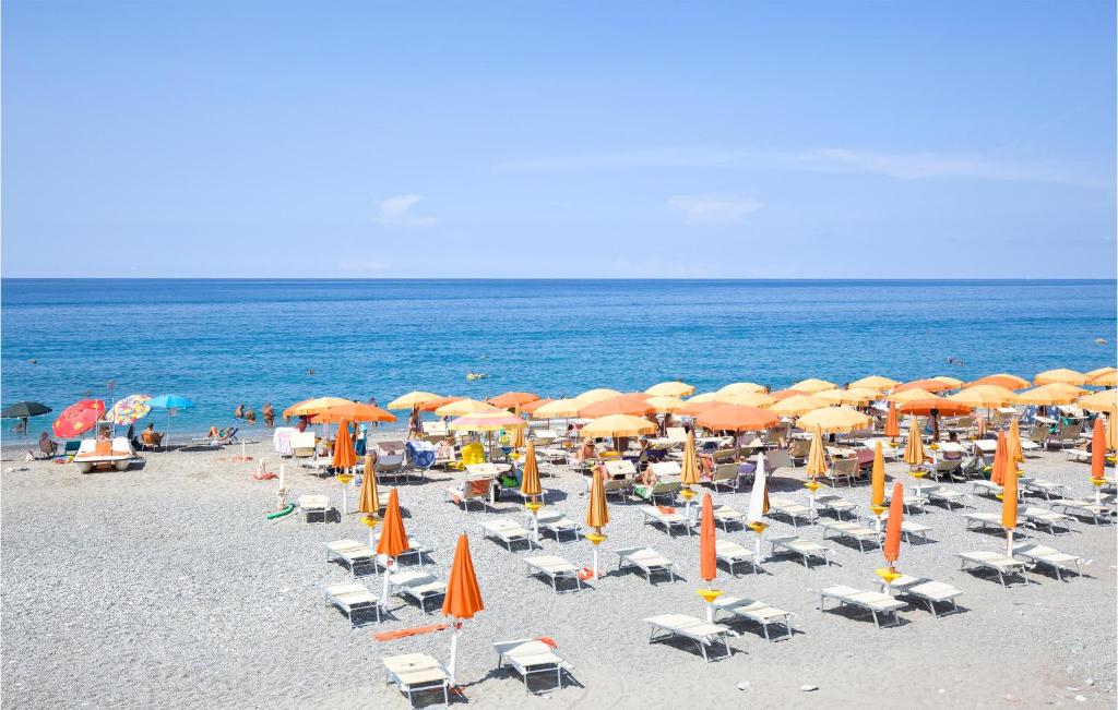 un montón de sillas y sombrillas en una playa en 2 Bedroom Lovely Apartment In Marina Di Strongoli, en Marina di Strongoli