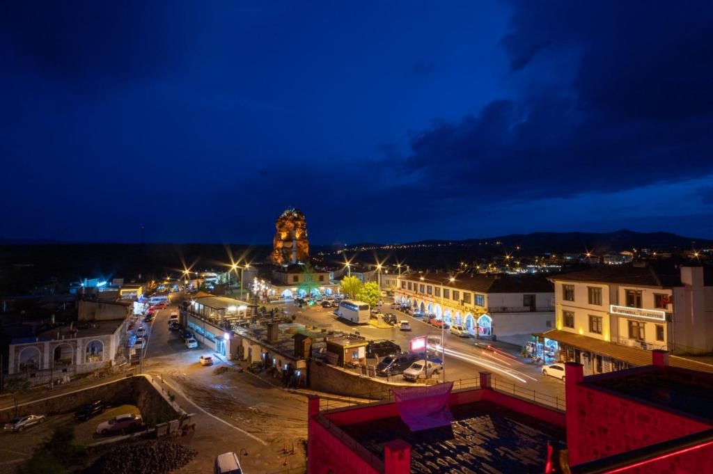 Una ciudad de noche con una torre de reloj a lo lejos en hotels crazy horse en Ortahisar