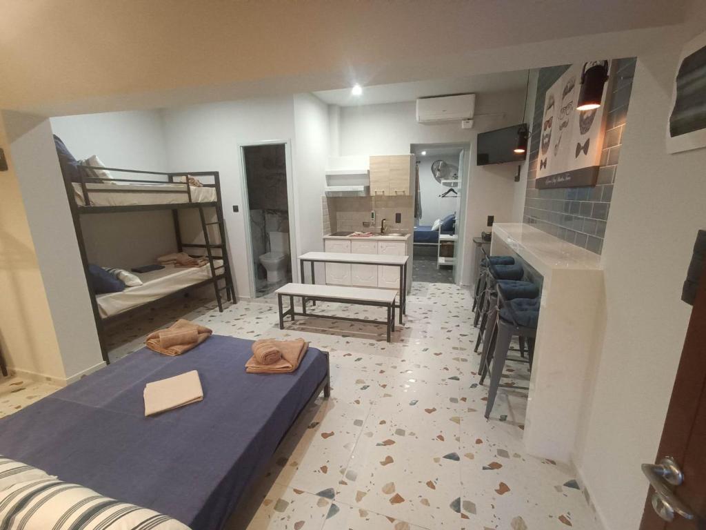 Pokój z 2 łóżkami piętrowymi, stołem i krzesłami w obiekcie Grecos STAY SKIATHOS w mieście Skiatos