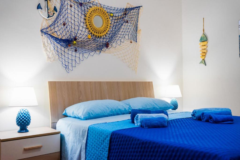 Un dormitorio con una cama con sábanas azules y una mosquitera. en Sunset Apartment Palese - A 10m dal mare, en Bari