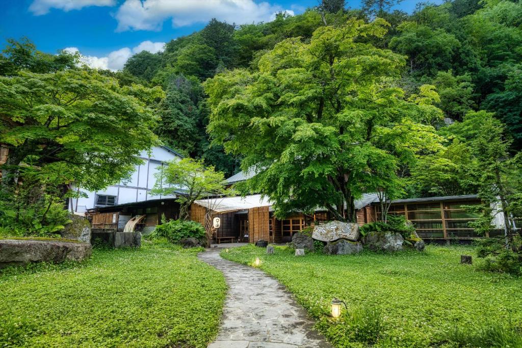 um caminho que leva a um edifício com uma árvore em Hacho no Yu em Nikko