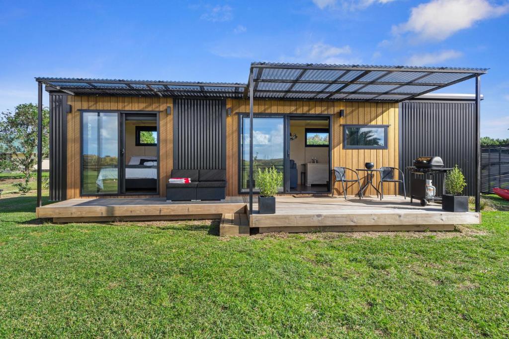 a tiny house with a metal roof at Peace in Paradise - Tokerau Beach Holiday Home in Tokerau Beach