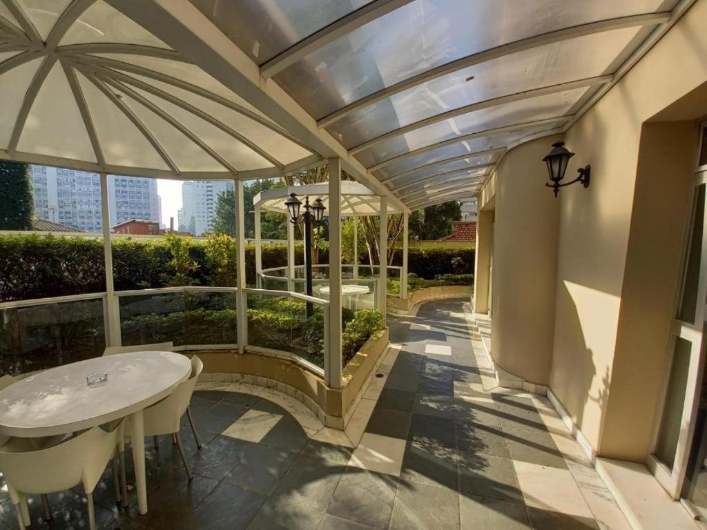 eine Terrasse mit einem weißen Tisch und einem Sonnenschirm in der Unterkunft Paulista Flat in São Paulo