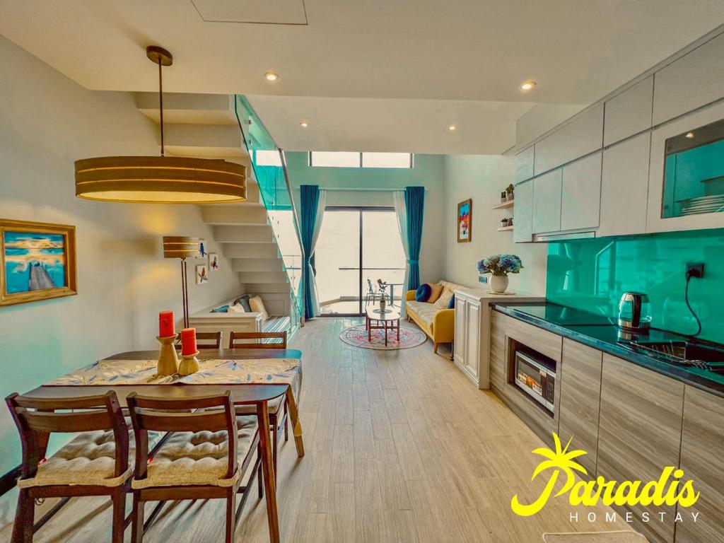 a kitchen and living room with a table and chairs at Paradis Homestay Marina Ha Long in Ha Long