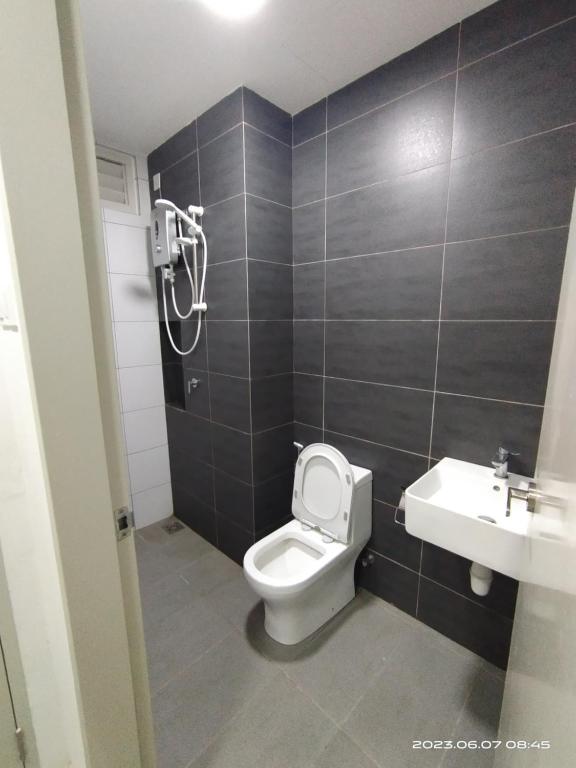 a bathroom with a toilet and a sink at Horizon Suites Sepang - Studio Unit in Kampong Melot