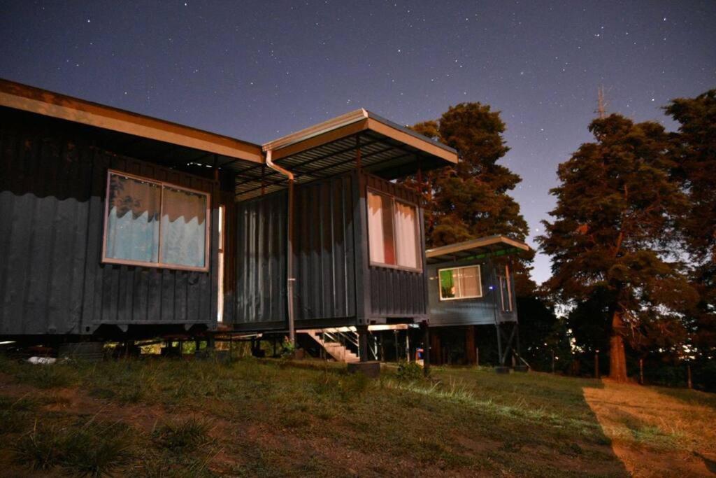 uma casa sentada em cima de um campo à noite em Epimoni em Poás