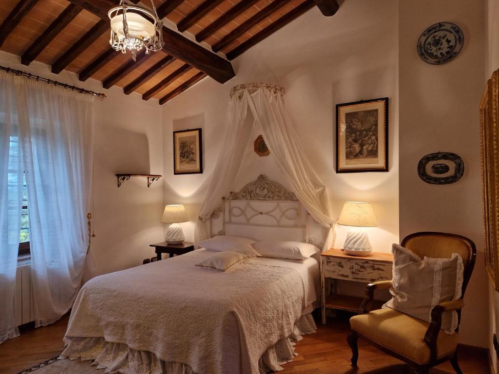 een slaapkamer met een wit bed en een stoel bij Casa Crevole in Palazzina