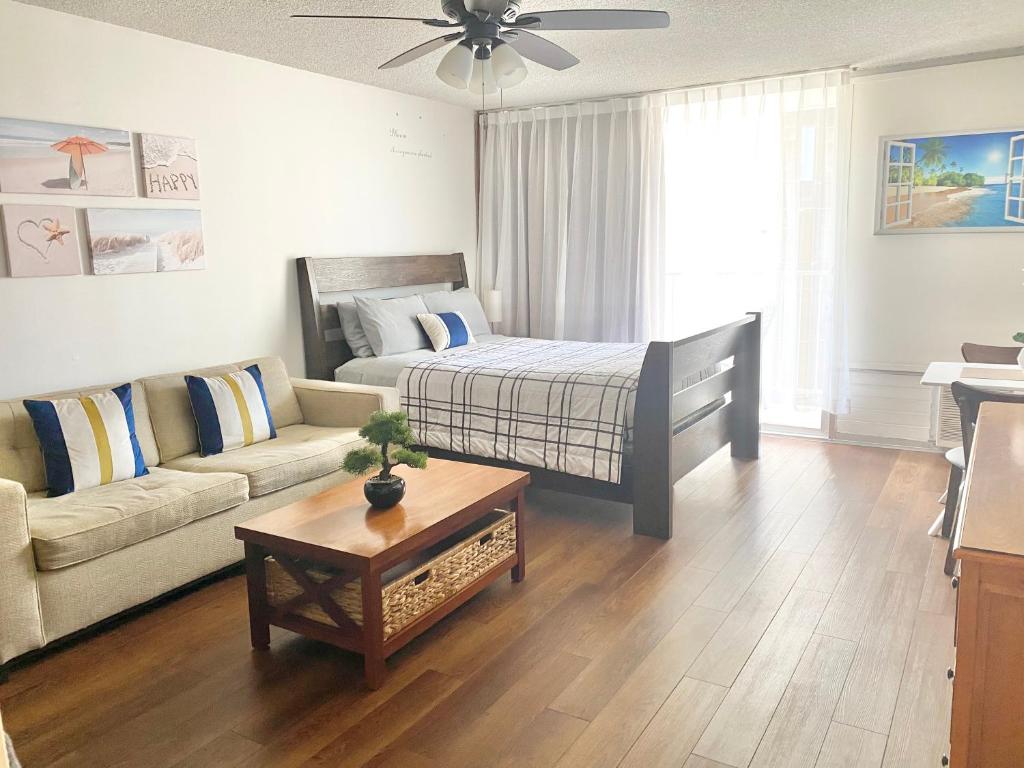 uma sala de estar com uma cama e um sofá em Free parking Comfy central Waikiki em Honolulu