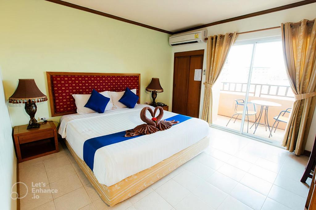 a bedroom with a large bed and a balcony at Thipurai Beach Hotel in Hua Hin