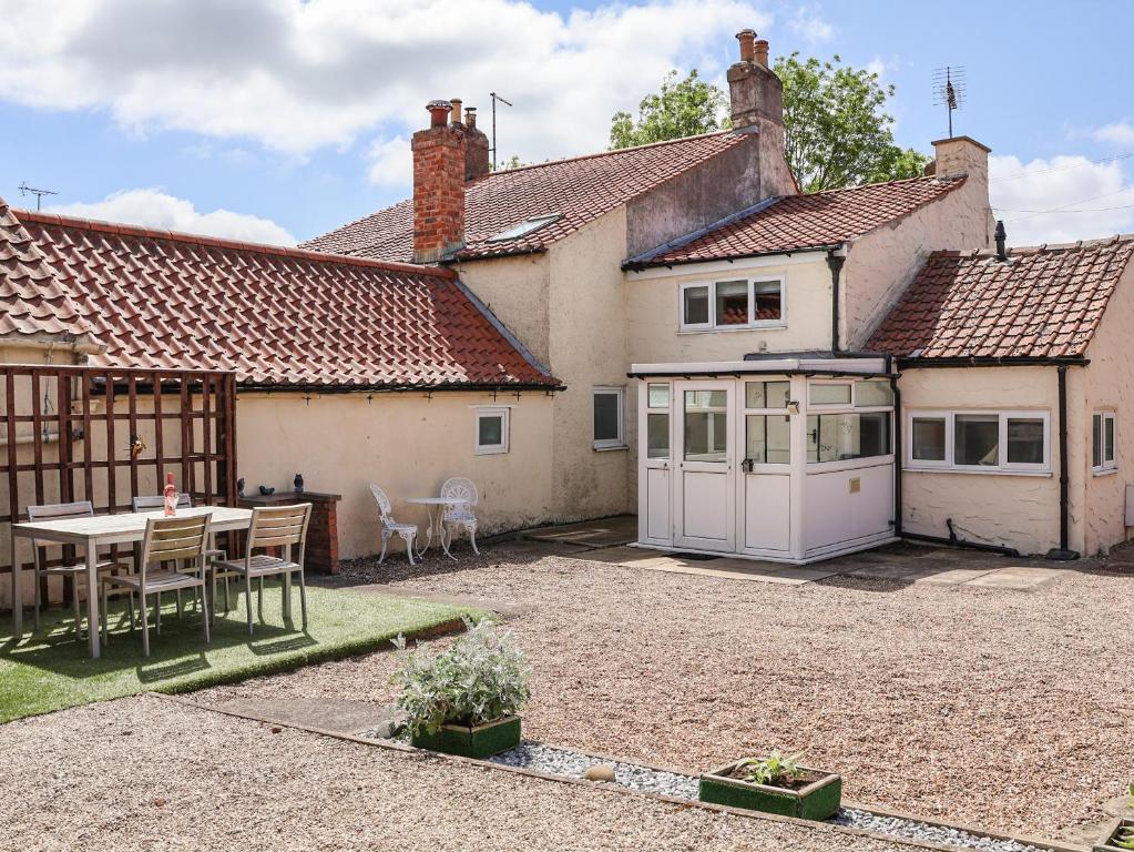 a house with a patio and a table in a yard at Lena Cottage in Great Driffield