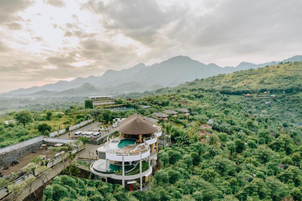 an aerial view of a building with mountains in the background at Sumberkima Resort in Pemuteran