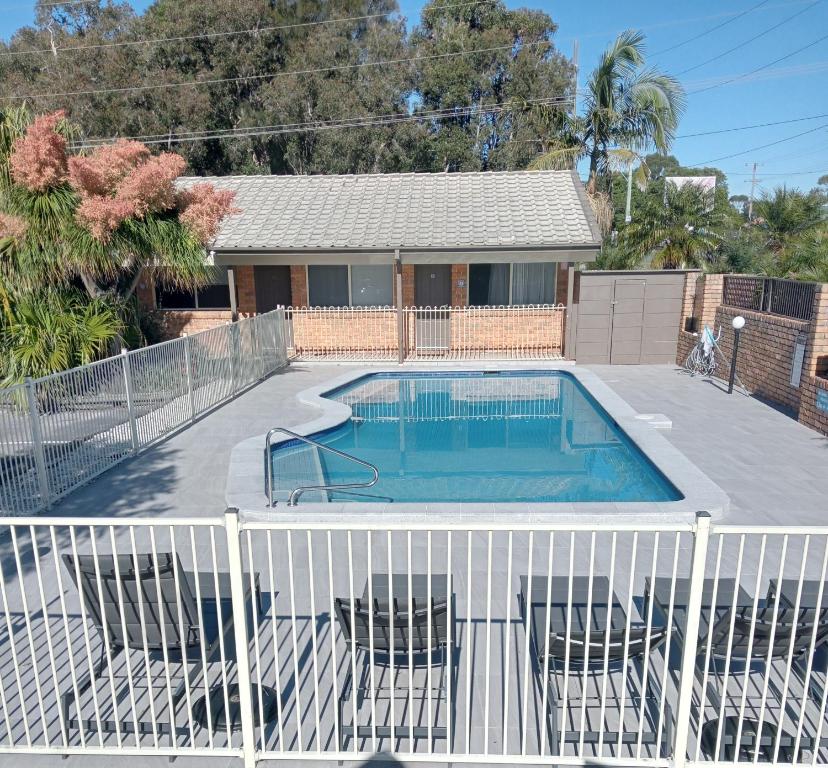 a swimming pool with a fence around it at Forster Palms Motel in Forster