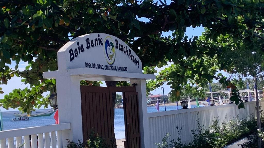un panneau indiquant une porte à la plage avec une clôture dans l'établissement Baie Benie Beach Resort, à Balibago