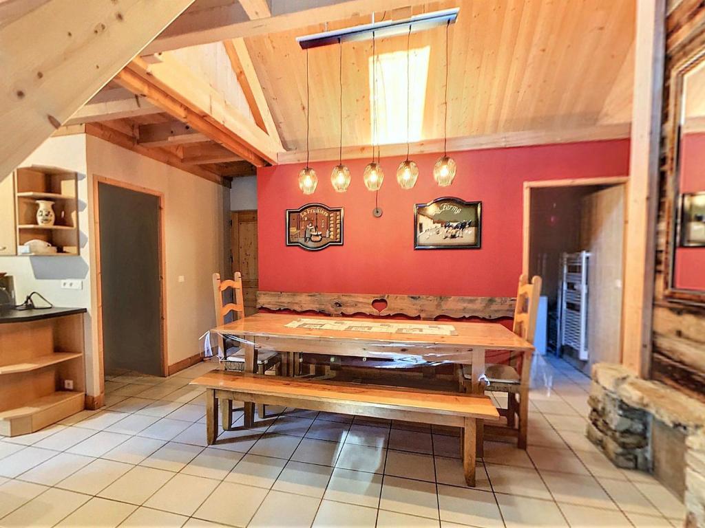 a dining room with a table and a red wall at Grand Appartement Confortable 10/12 Pers, Terrasse, Parking - FR-1-267-250 in Villarembert