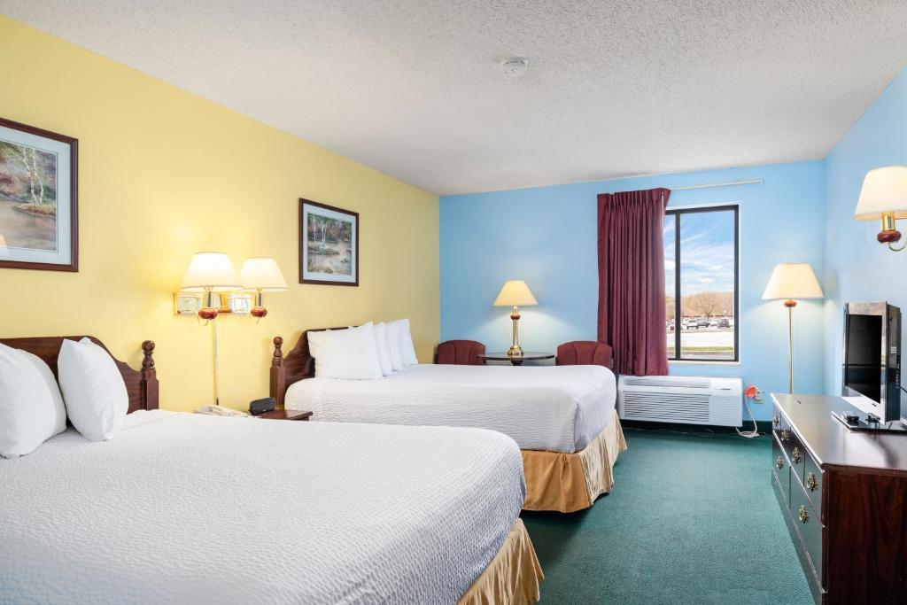 a hotel room with two beds and a window at Days Inn by Wyndham Battlefield Rd/Hwy 65 in Springfield