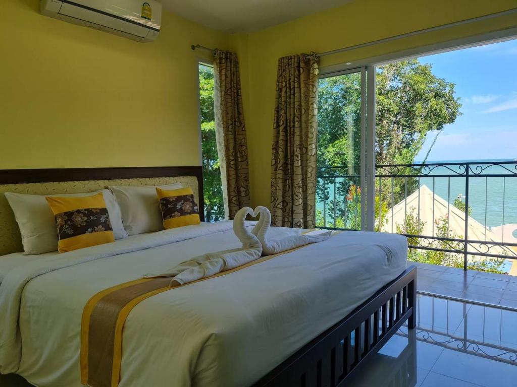 a bedroom with a large bed with a large window at Chom By The Sea in Ao Nam Mao