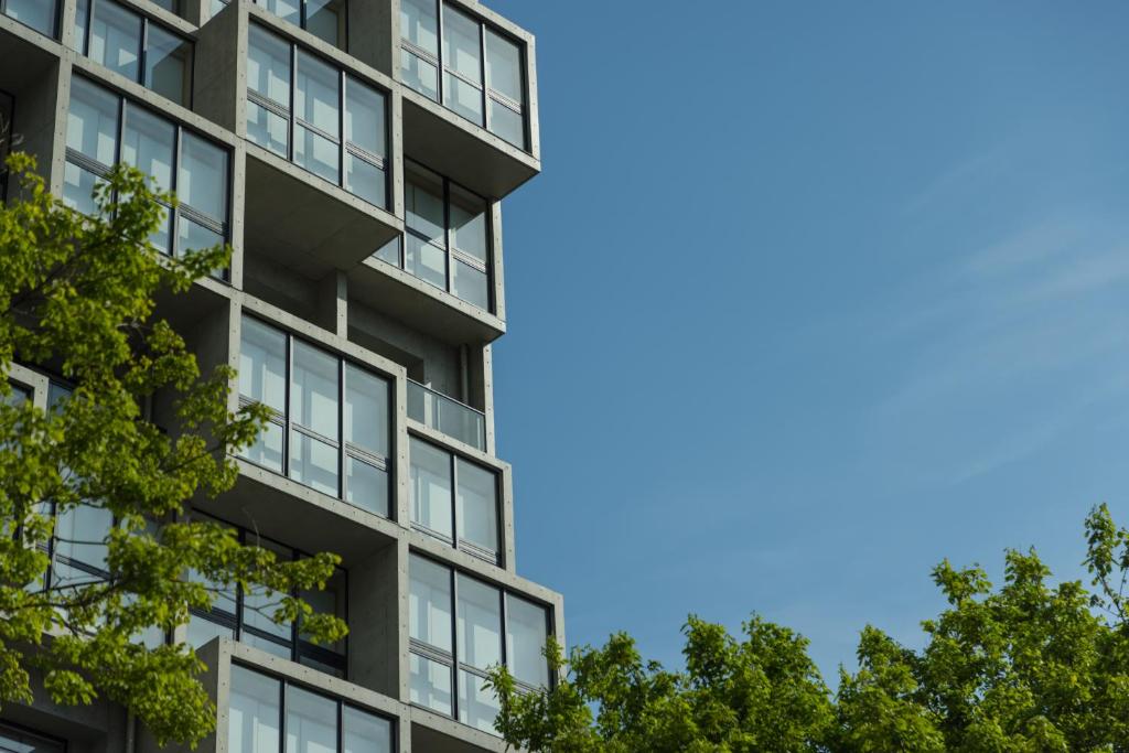 un edificio de apartamentos con árboles en el primer plano en 9 HOTEL Hakata en Fukuoka